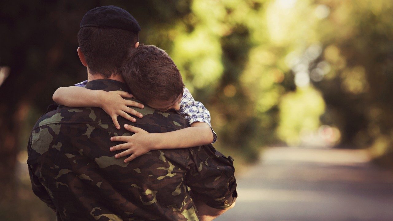 Father in uniform silhouette holding young son